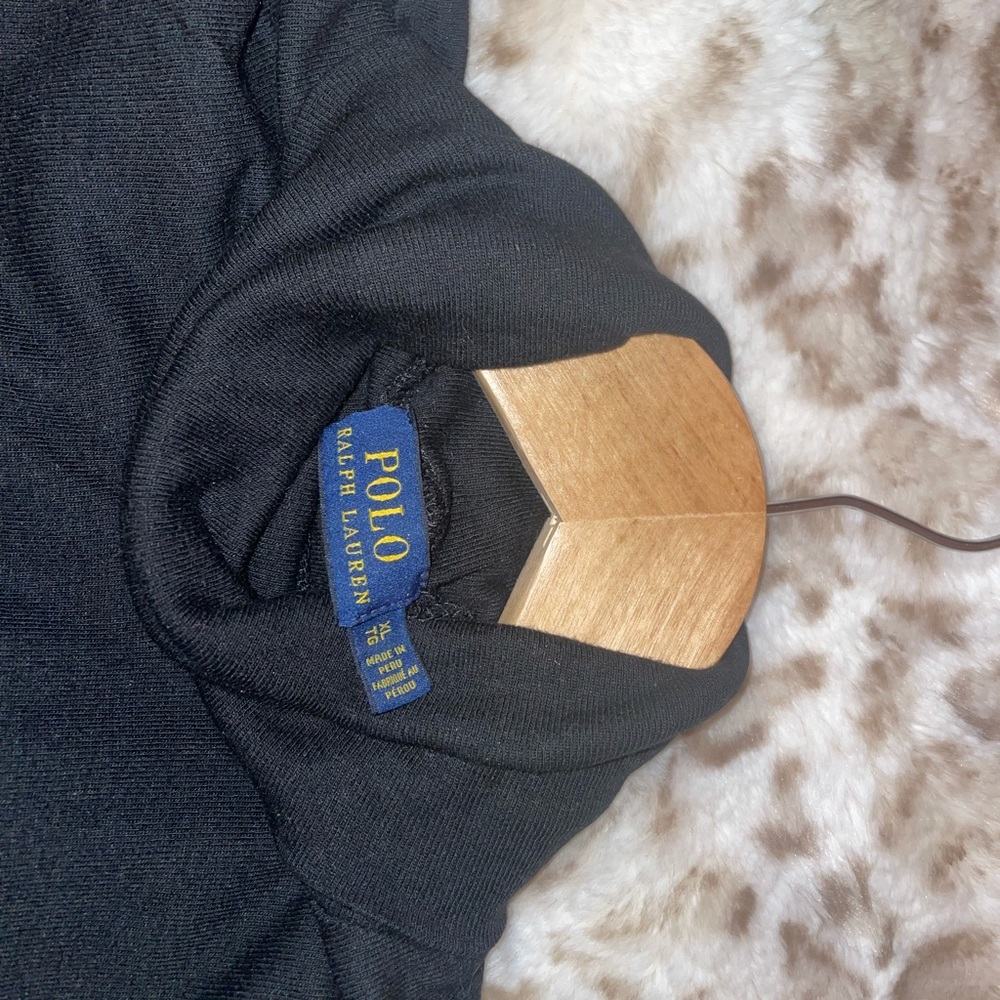 Black turtleneck sweater. It’s says extra large but fits more like a medium.